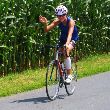 Holly waves while riding among the cornfields